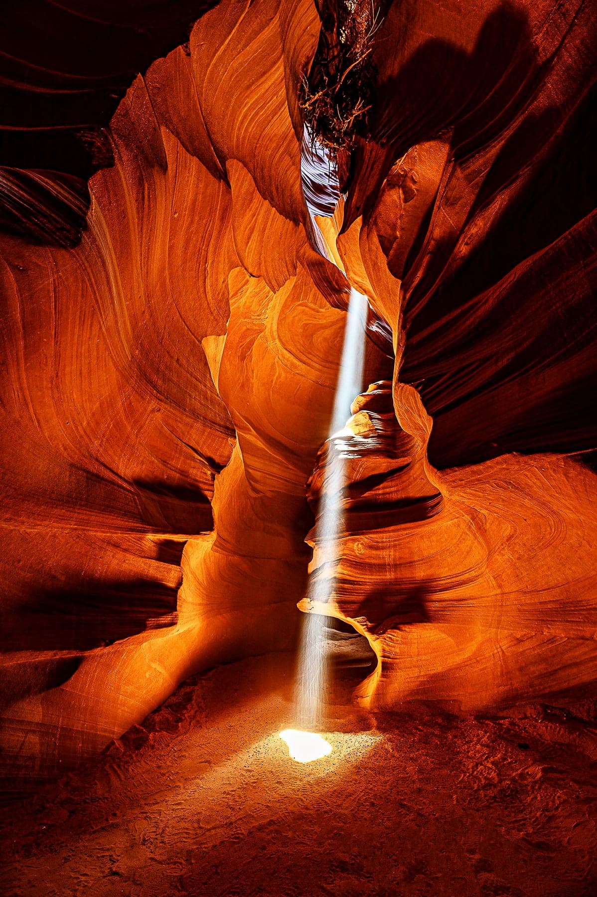 A shaft of sunlight piercing the orange walls of a slot canyon
