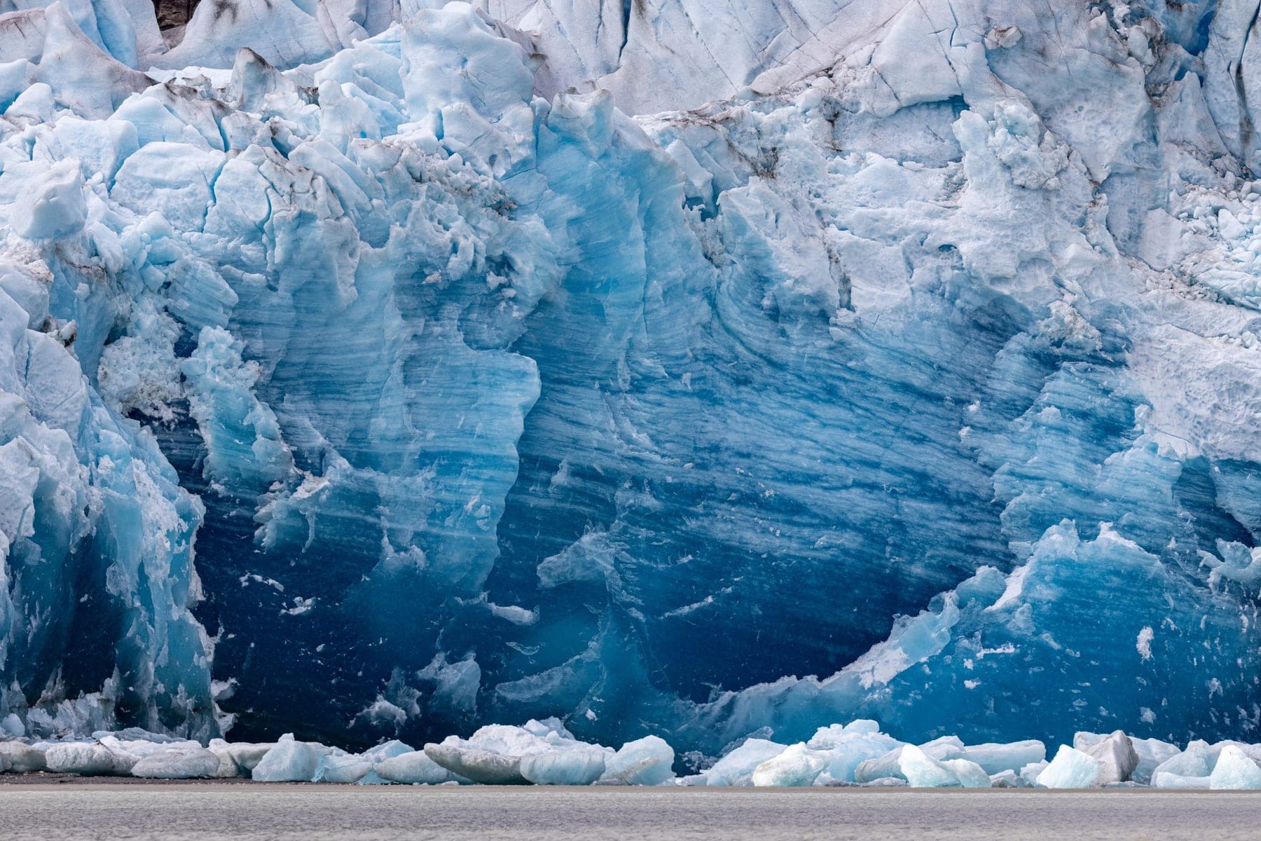 Deep blue glacial ice catching the cold light of blue hour
